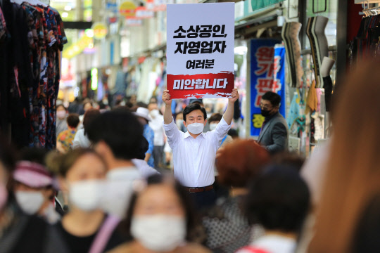 국민의힘 대선주자 일원인 원희룡 전 제주지사가 19일 대구 중구 서문시장에서 문재인 정부의 코로나19 방역 조치 비판 차원에서 '소상공인, 자영업자 여러분 미안합니다'라고 적힌 피켓을 들고 1인 시위를 벌이며 지지를 호소하고 있다.원희룡 캠프 제공 사진